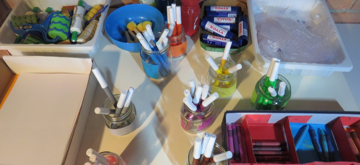 Foto di un tavolo con pennarelli, matite e pastelli