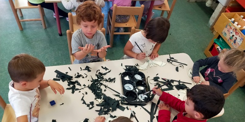 Bambini seduti al tavolo mentre dipingono