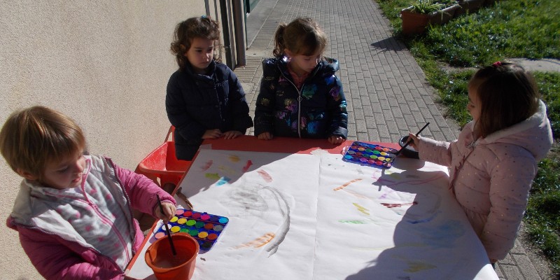 Bambini in giardino mentre dipingono con gli acquarelli