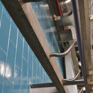 Foto dettaglio dei ganci sulla parete con piastrelle azzurre delle Ex Celle Frigo di Officina Giovani.