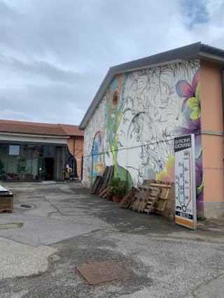 Foto a cololri dell\'esterno dell\'acquario, all\'ingresso del bar, e facciata capannone centrale con il murales di R. Biancalani.