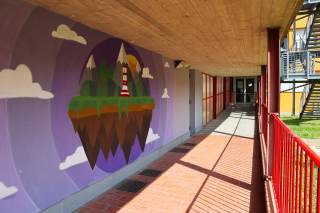 Murales Scuola Lippi di mondo fantastico sospeso: con montagne e un faro su cielo viola e nuvole bianche.