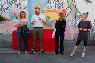 quattro persone con dietro un murales