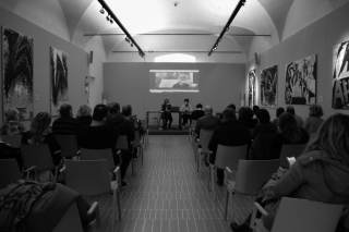 persone sedute in una stanza che assistono ad una conferenza