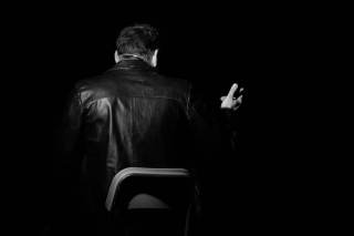 attore seduto di spalle