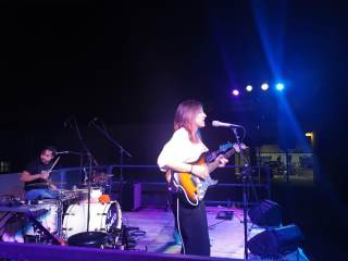 musicista che suona la chitarra sul palco