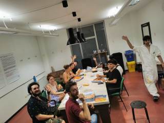 ragazzi a tavola mentre mangiano la pizza