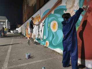ragazzi mentre realizzano un murales