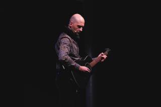 attore mentre suona la chitarra