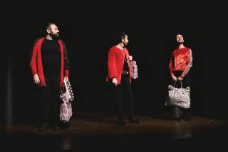 Gli attori sono vestiti di rosso e di nero ed hanno delle espressioni che emanano un qualcosa di incredulo.