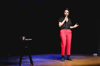 L\'attrice interagisce sul palco con gli oggetti di scena.