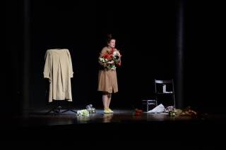 L\'attrice, a chiusura, tiene in mano dei fiori.