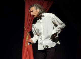 L\'attore indossa una camicia bianca.