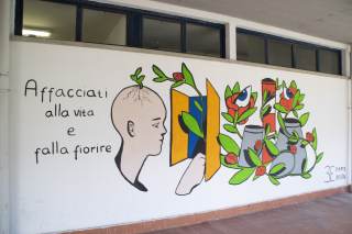 Foto del murales, accompagnato dalla frase "Affacciati alla vita e falla fiorire".