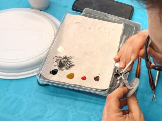 Un partecipante al laboratorio dipinge una miniatura