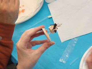 Un partecipante al laboratorio dipinge una miniatura