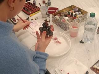 Un partecipante al laboratorio dipinge una miniatura