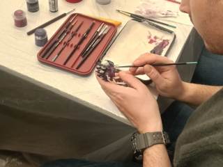 Un partecipante al laboratorio dipinge una miniatura