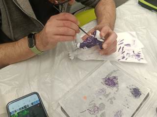 Un partecipante al laboratorio dipinge una miniatura