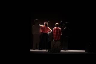 Foto dello spettacolo. I due attori sono di spalle al pubblico.