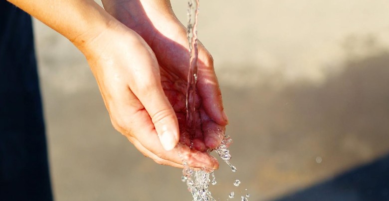 Immagine di persona che si lava le mani a una fontanella